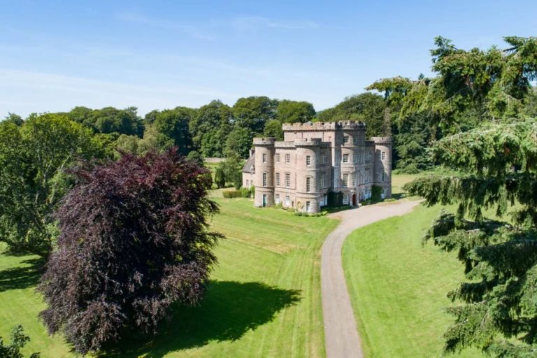 Lawned grounds of Monzie Castle, Perthshire, Scotland with the elegant castle in the distance