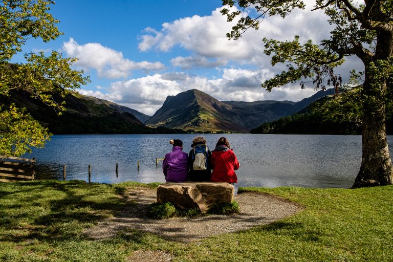 female hikers relax on a bench , Buttermere, Lake District