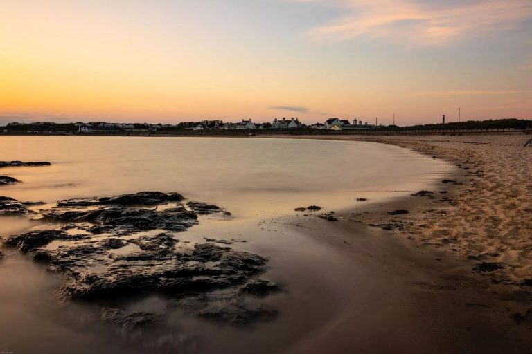 A sandy beach in Trearddur Bay, Anglesey, at sunset