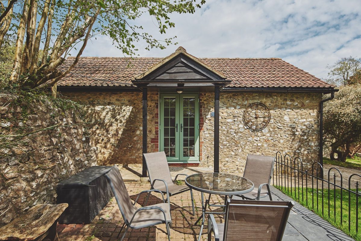 The exterior and outdoor dining area at Harcombe Cottage, Devon