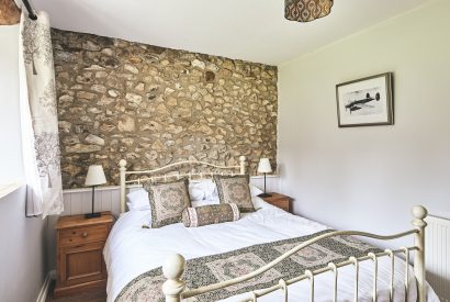 A bedroom with exposed brick at Tree Pipit Cottage, Devon