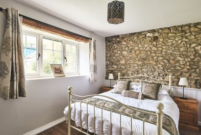 A bedroom with exposed brick at Tree Pipit Cottage, Devon