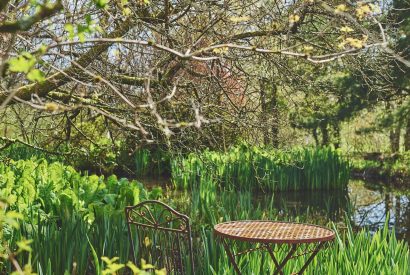 A seating area by the pond at Thresher's Cottage, Lake District