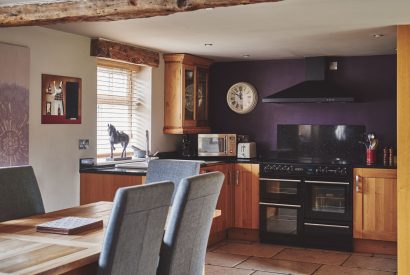 The dining table and kitchen at Green Pastures Cottage, Peak District