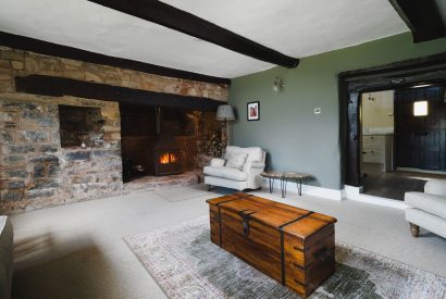 The sitting room with log burner at Holwell Farmhouse, Devon