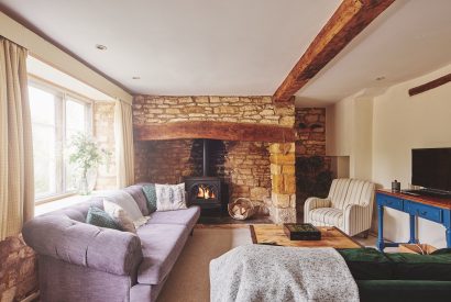 The living room with log burner at Church View Cottage, Cotswolds