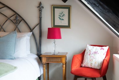 A single armchair in a double bedroom at Fig Tree Cottage, Cotswolds