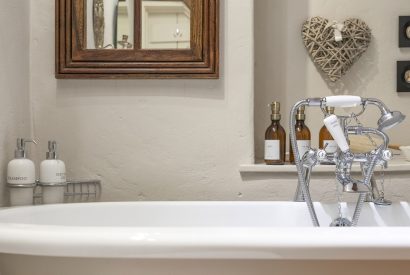 The free-standing bath with luxury toiletries at Fig Tree Cottage, Cotswolds