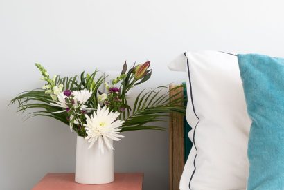 A vase with flowers in the master bedroom at Waters Dream, Devon