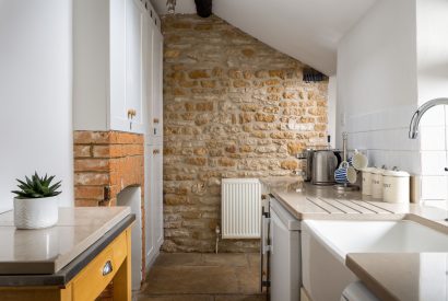 The kitchen with exposed brick wall at Upper Cottage, Cotswolds