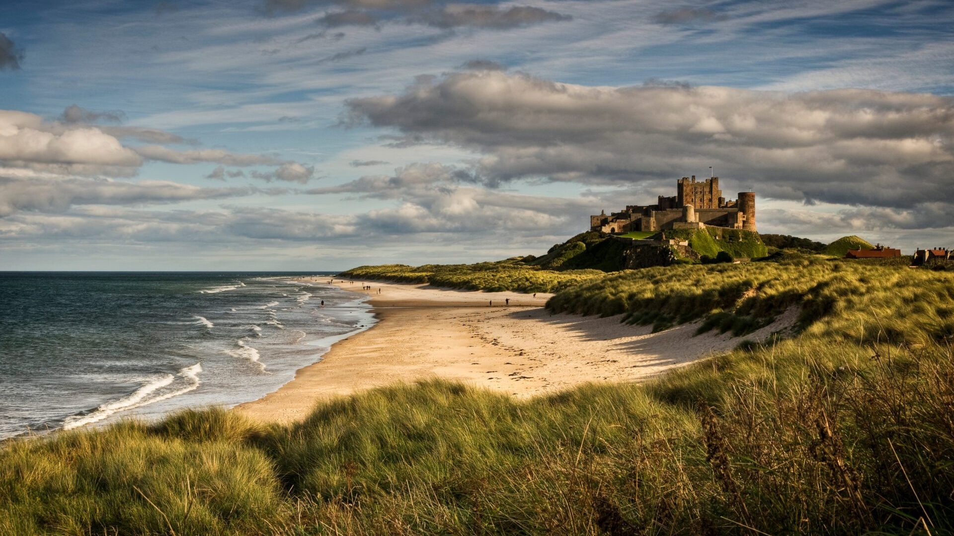 Late Afternoon Light Illuminates The Castle And Beach At Bamburg