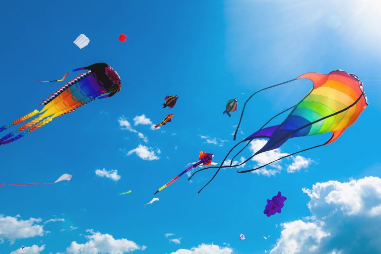 Colourful Kites Flying Across A Blue Sky