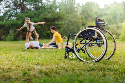 Disabled Man Lifting Up His Daughter On Picnic