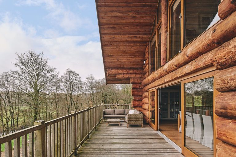 Wrap-around balcony of Larch Cabin in Cumbria with view over Liddel Water