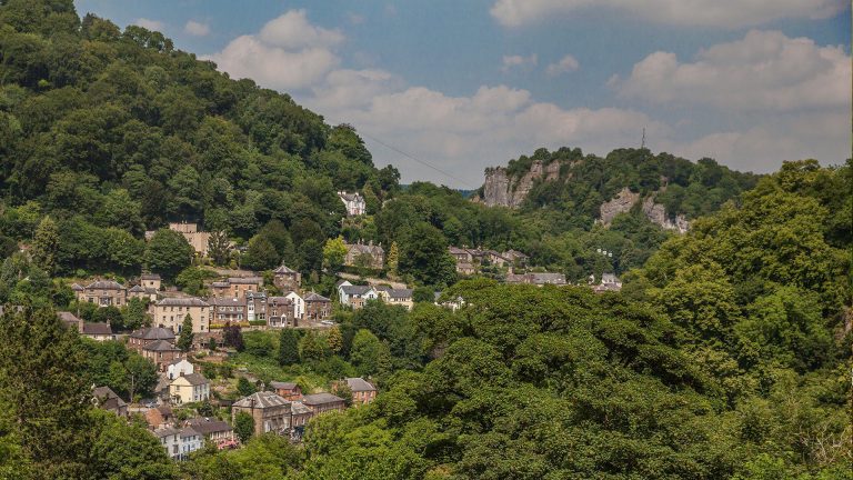 a village in the hills surrounded by woodland in Matlock
