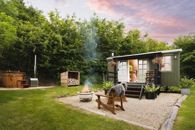 Outside of Red Deer Escape log cabin in Exmoor, Somerset with hot tub and deck chairs