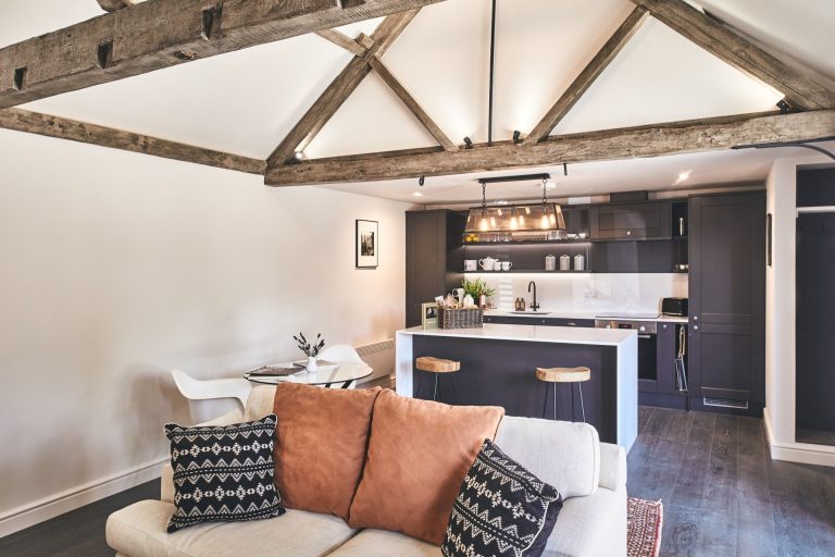 Open-plan lounge and kitchen with wooden beams at The Stables, Near Stratford-upon-Avon