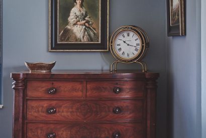 An antique chest of draws and paintings at Equestrian Manor, Malvern Hills