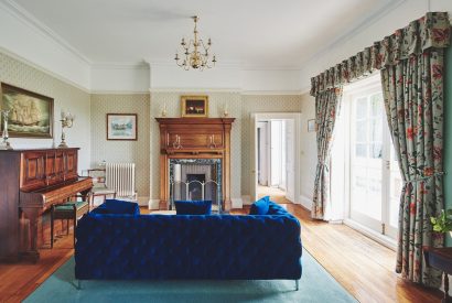 A sitting room with a piano at Equestrian Manor, Malvern Hills