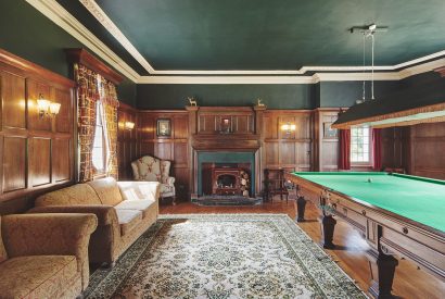 A games room with a fireplace at Equestrian Manor, Malvern Hills