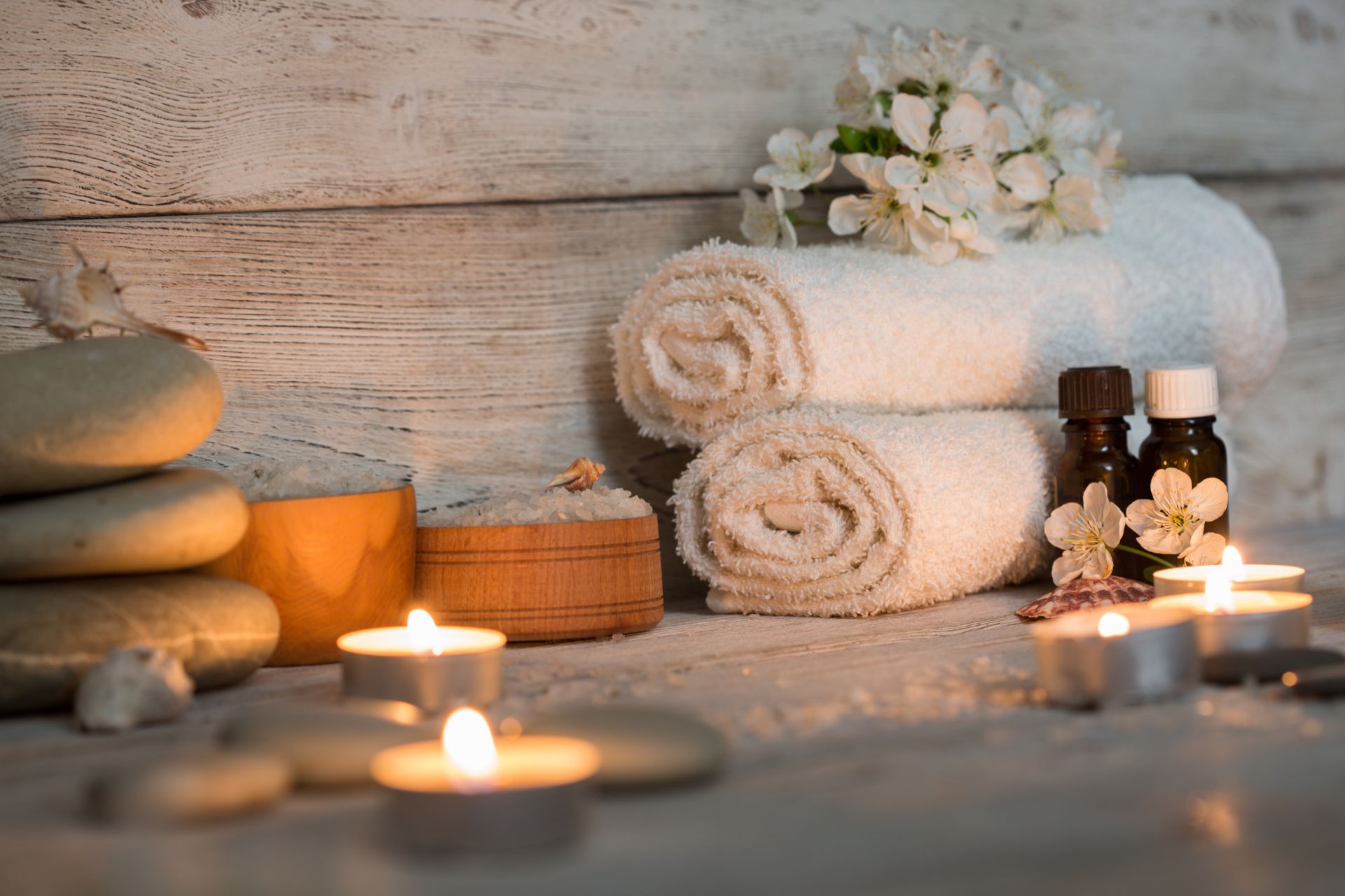Candles, towels and aromatherapy oils set up for a spa treatment