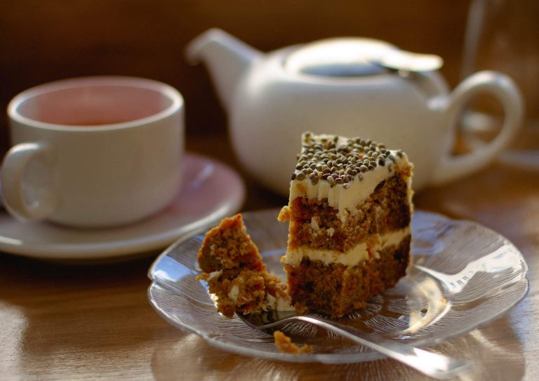 A piece of cake alongside a pot of tea and cup