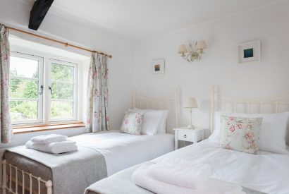 A twin bedroom overlooking the garden at Hempston Cottage, Devon