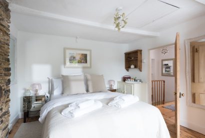 A double bedroom with stone wall feature at Hempston Cottage, Devon