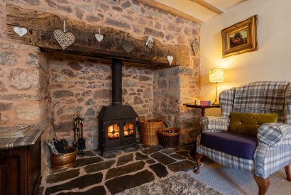 The living room with a log burner at Sweet Shop Cottage, Somerset