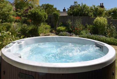 The hot tub set within the peaceful garden at Thatch Corner, Somerset