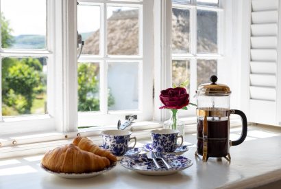 A cafetiere and croissant in the window at Thatch Corner, Somerset