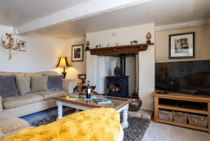 The living room with a log burner at Thatch Corner, Somerset