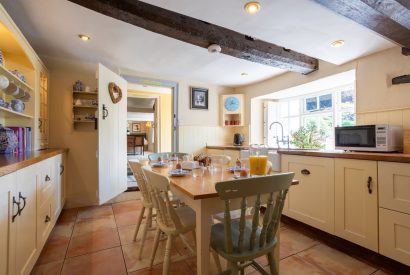 The kitchen with a large dining table at Thatch Corner, Somerset