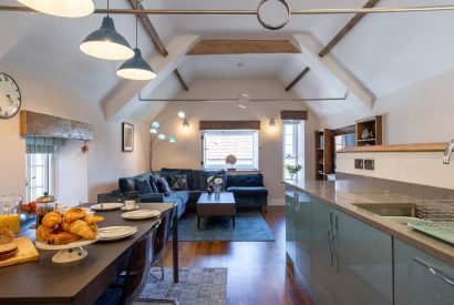 The kitchen and living room with a vaulted ceiling and beams at Exmoor Barn, Somerset