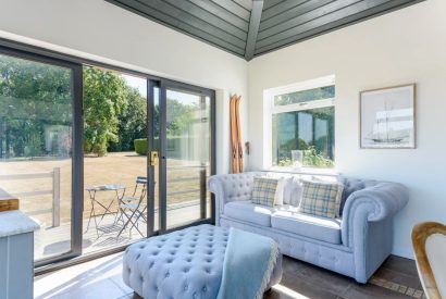A sitting room with doors onto the garden at Brickworks and Vines, Isle of Wight