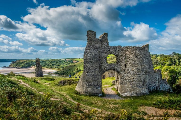 Ruins of Pennard Castle with sea view of Gower Peninsula in the background