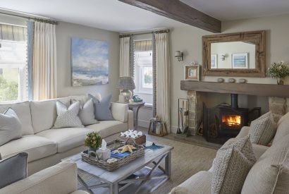 The living room with a log burner at The Beach House, Devon