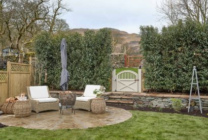 An outdoor seating area and fire pit at Beatrix Cottage, Lake District