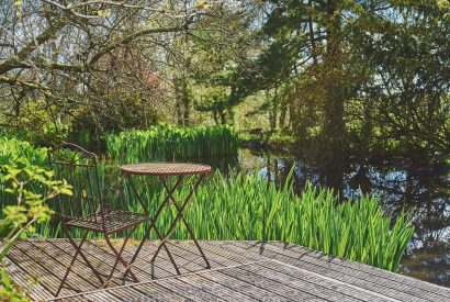 A seating area next to the pond at Twitchers Cottage, Lake District