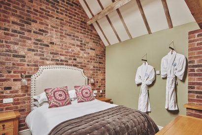 The king-size bed and fluffy robes at The Dairy Barn, Worcestershire 