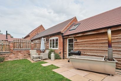 The private garden with a wood-fired Swedish Hikki hot tub at The Dairy Barn, Worcestershire 