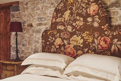The floral headboard of the king-size bed at Lotus Cottage, Vale of Glamorgan