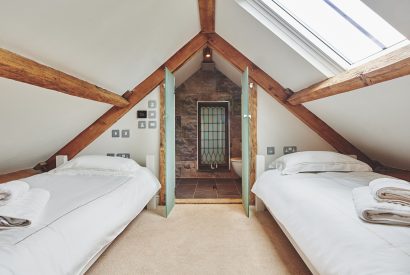A twin bedroom with an en-suite at Lotus Cottage, Vale of Glamorgan