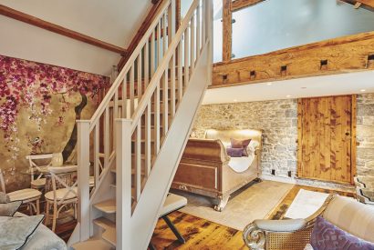 The staircase to the mezzanine level and king-size bed at Hollyhock Cottage, Vale of Glamorgan