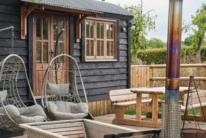 The egg chairs, outdoor dining table and wood-fired Swedish Hikki hot tub at The Hangout Hut, Worcestershire 