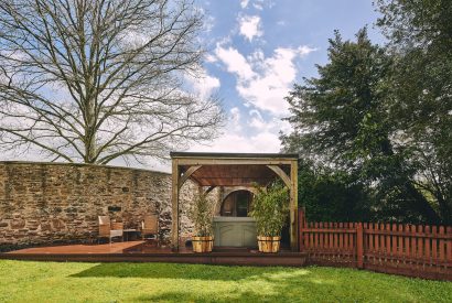 The private garden with a hot tub and barrel sauna at Osborne Lodge, Herefordshire