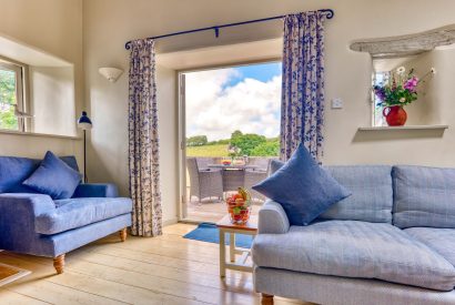 The living room with a balcony overlooking the countryside at Harberton Cottage, Devon