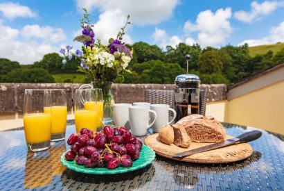 Breakfast on the dining table outside at Harberton Cottage, Devon