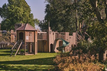 The play area with a climbing wall and slide at Victoria Lodge, Welsh Borders