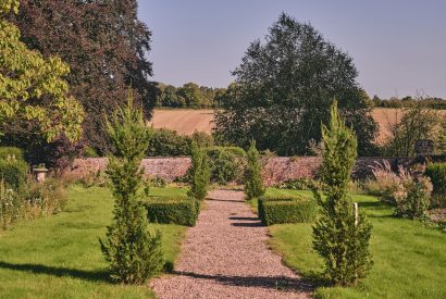 A cobbled pathway through the estate grounds overlooking the countryside at Victoria Lodge, Welsh Borders